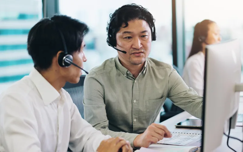 Support specialists wearing headsets working at their desks